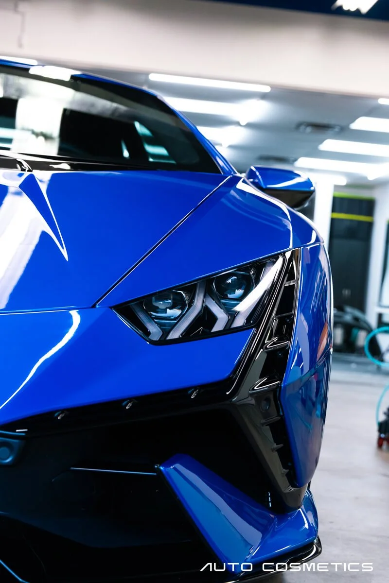 Auto Cosmetics technician hand-finishing a protected vehicle panel inside the Chandler shop