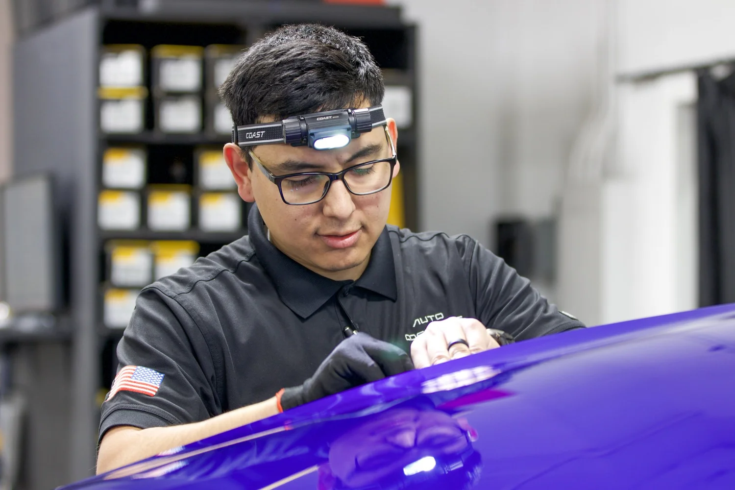 Factory-trained clear bra installer applying film at Auto Cosmetics in Chandler, Arizona