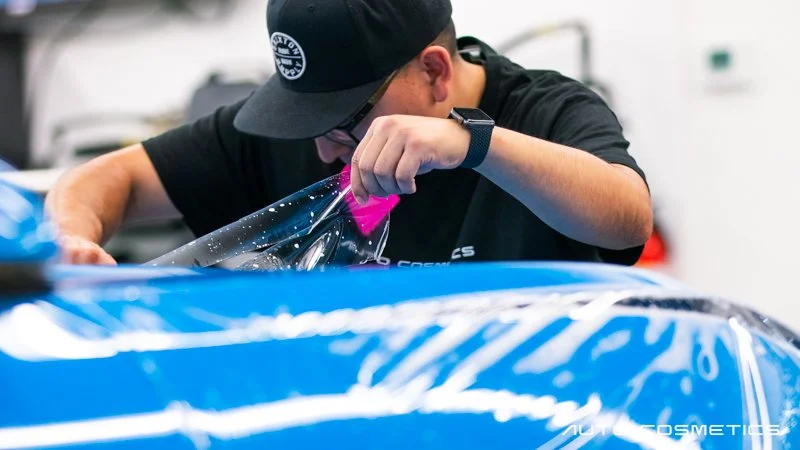 Factory-trained installer applying paint protection film at Auto Cosmetics, serving Phoenix drivers