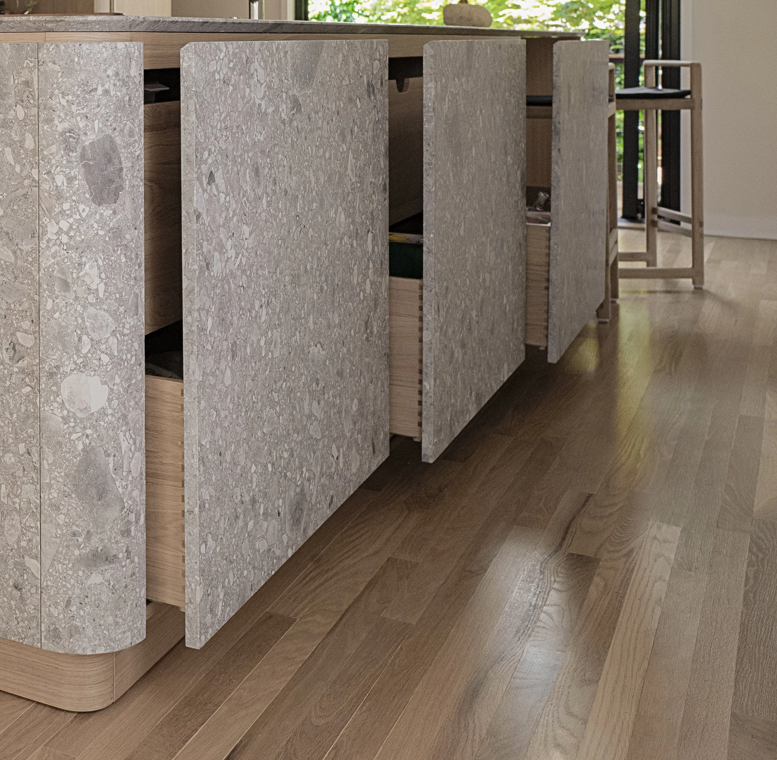 Una cucina moderna con pavimento di legno e un mobile con ante di pietra