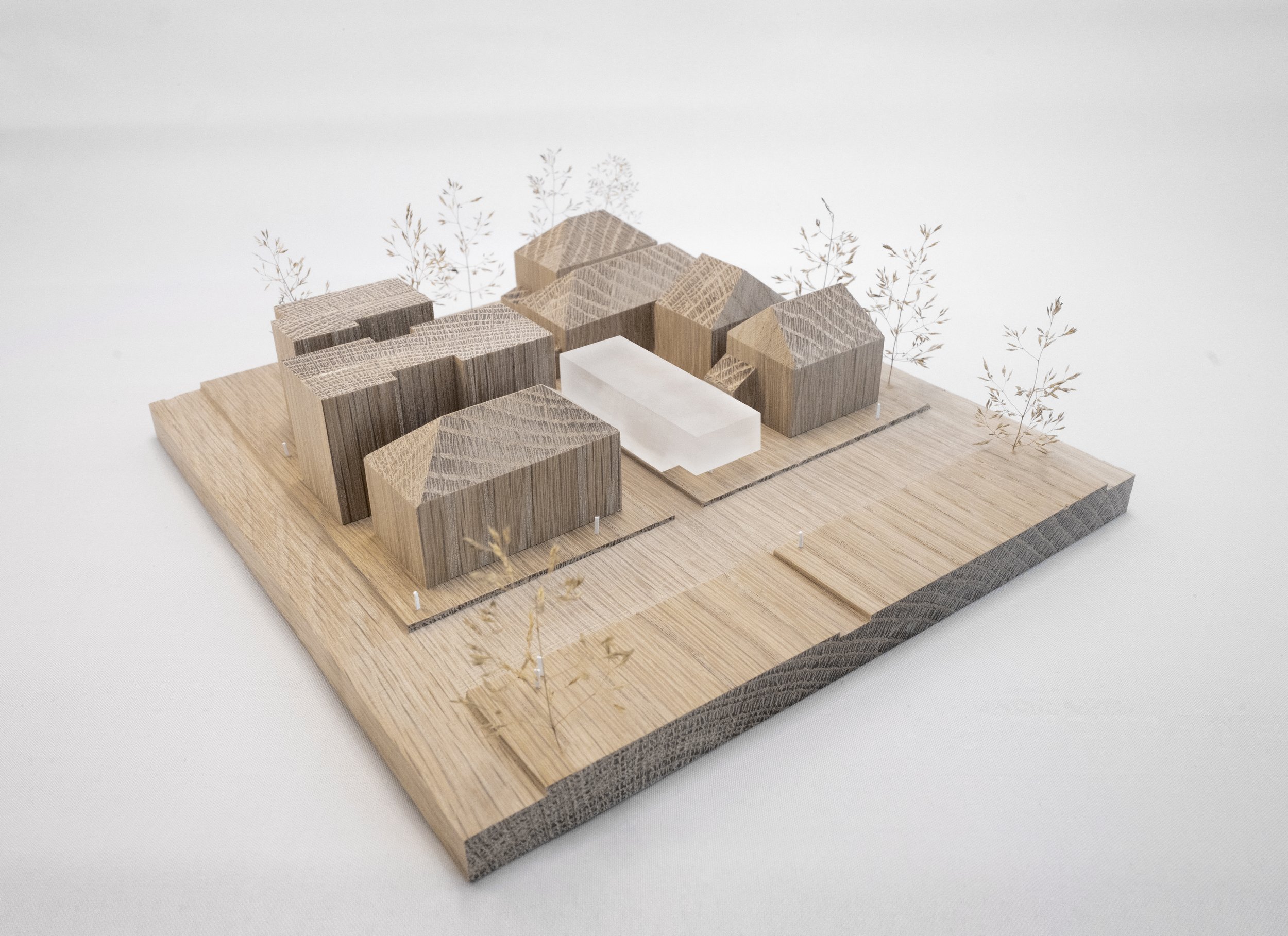Modello architettonico in legno di un complesso residenziale con edifici, spazi aperti e alberi finte.