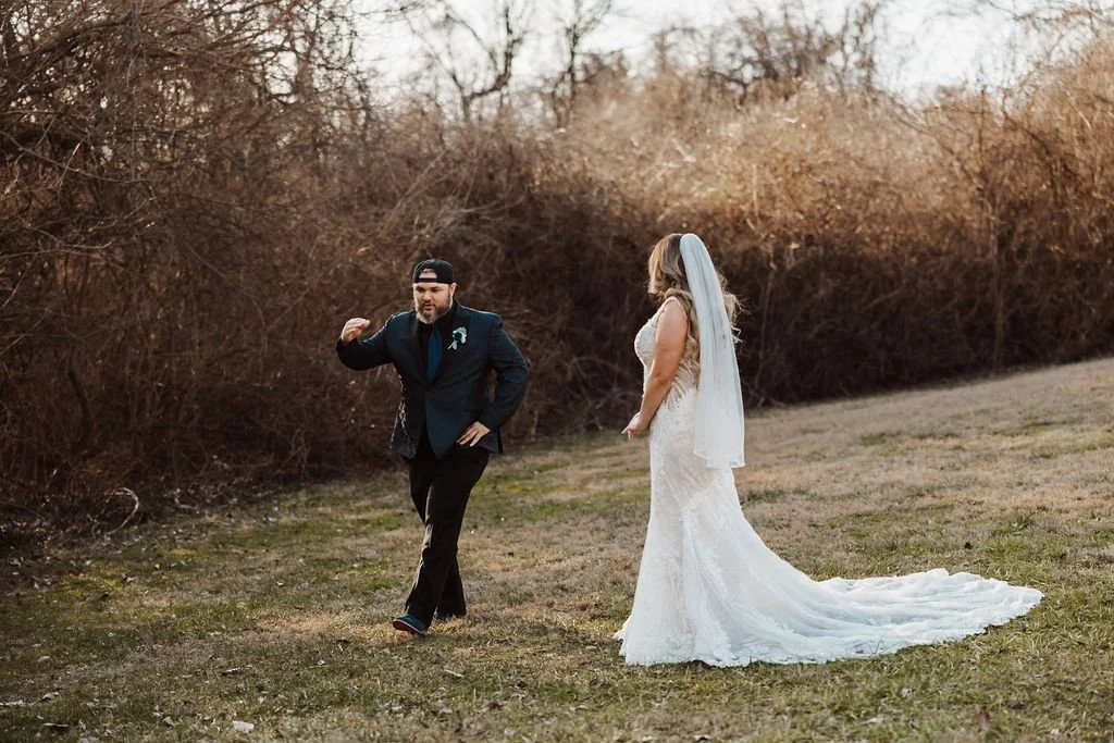 A man in a suit walking away from a woman in a wedding dress outdoors.