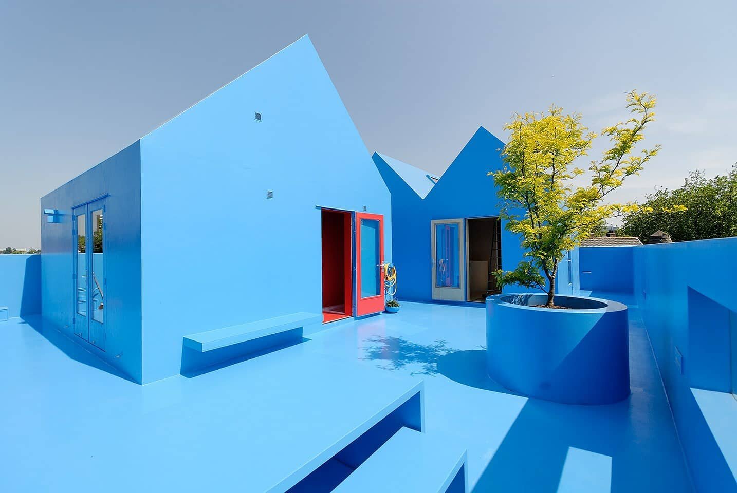 A blue crown atop an old stone building, an extension of the sky; or &quot;heaven&quot; as the architects say. Didden Village seeks to convert the unused roof of an old family home into a space that emulates a village while adding more function. Lade