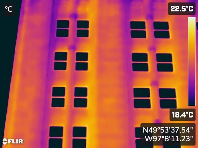 Thermal imaging view of a building facade with rows of windows, showing temperatures from 18.4°C to 22.5°C. winnipeg aerial roof and building envelope thermal inspections service