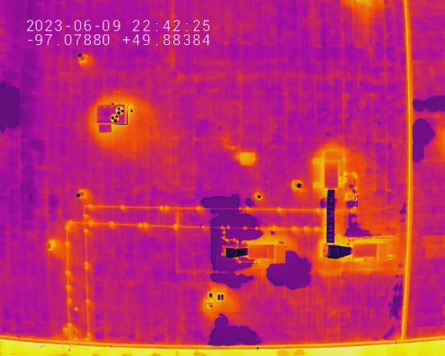Thermal imaging view of a brick wall showing warmer electrical components, wiring, and pipes. winnipeg aerial roof and building envelope thermal inspections service