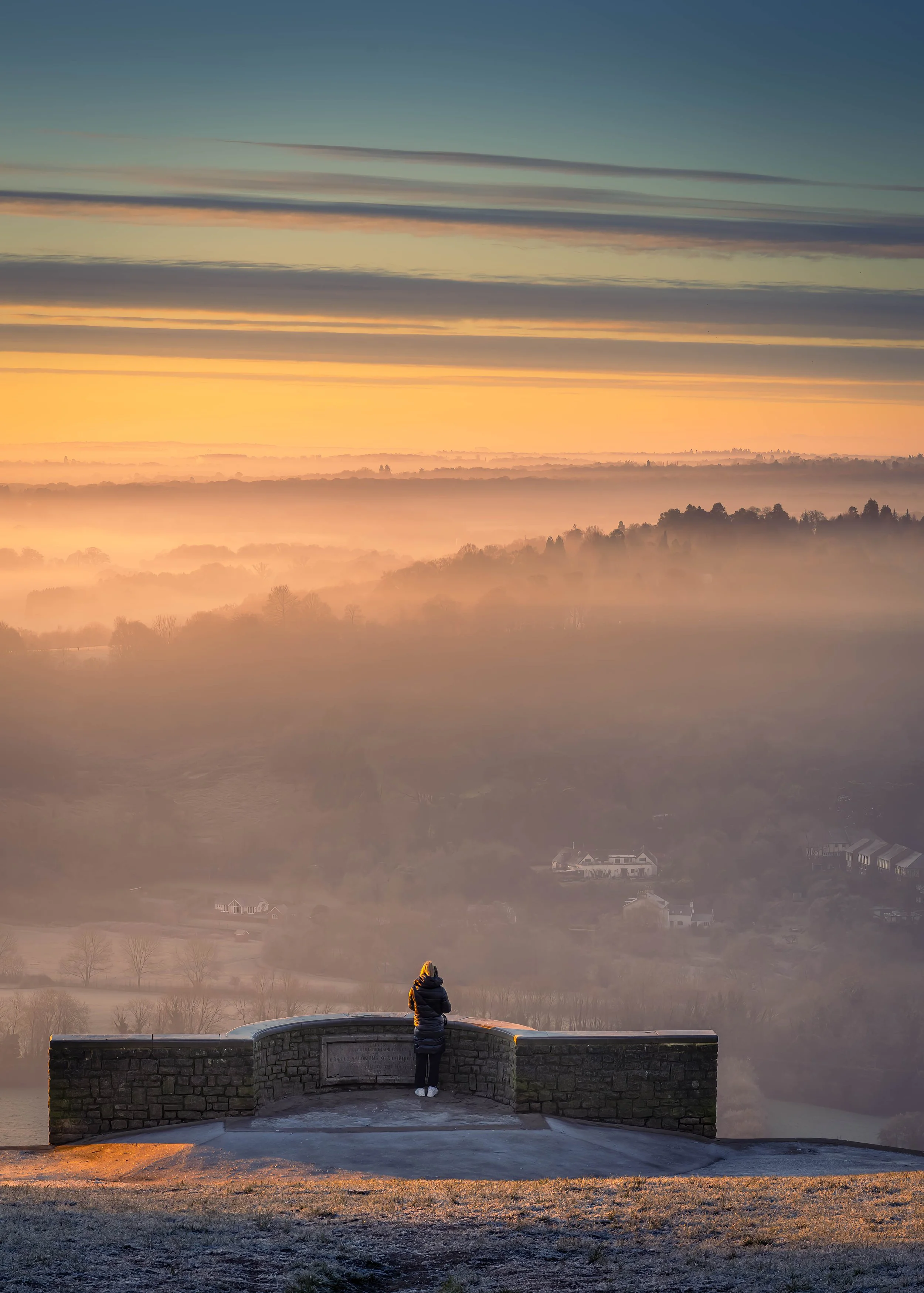 Person watching sunrise from viewpoint
