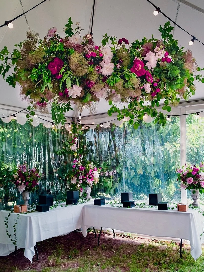 When I imagine wedding florals, I think of movement &mdash; how flowers can float, dance, and bring life to a space. For this celebration, we wanted guests to look up and feel surrounded by nature &mdash; an immersive garden under the tent. A mix of 