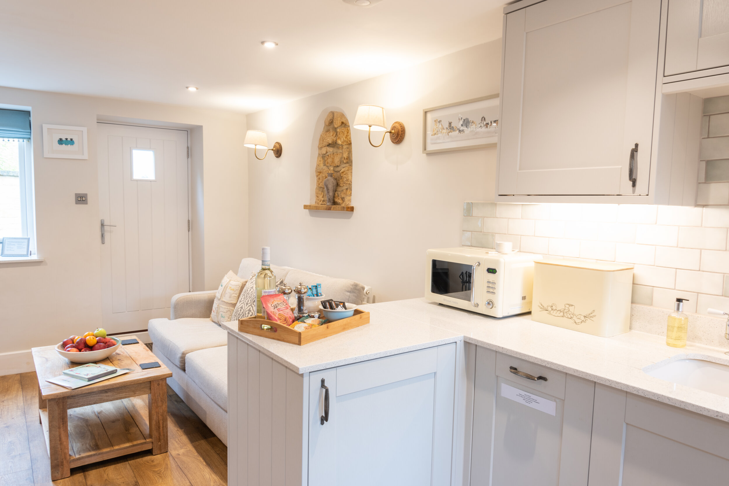 A bright, modern holiday rental kitchen and living space complete with a styled guest welcome tray