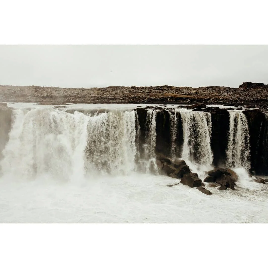 Icelandic waterfall in a rocky landscape with water cascading over cliffs.
