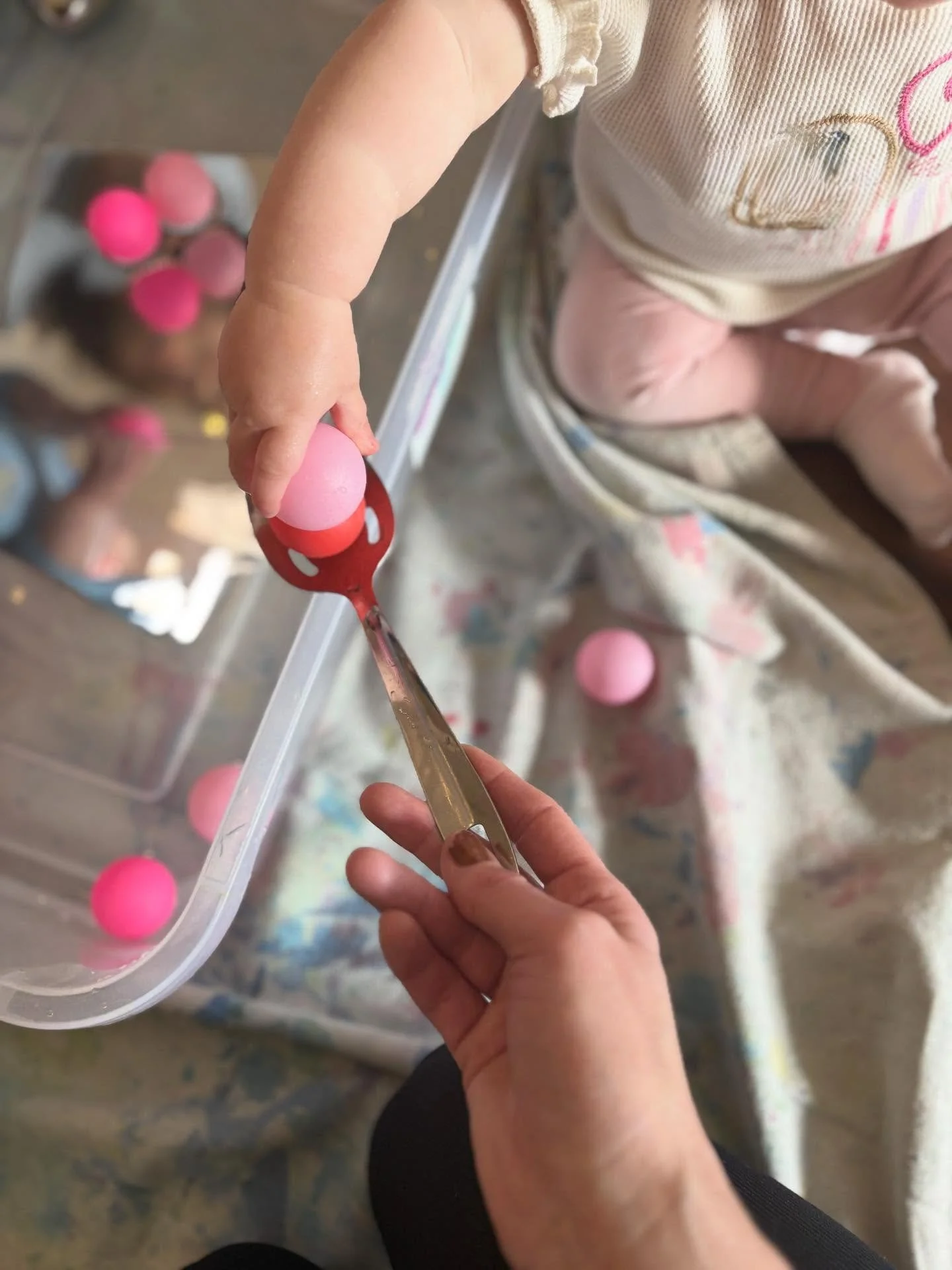 Today at Messy Minis (6-18 months), the group was busy exploring everything- Playdough with loose parts, water with balls and mirrors, and filling and dumping in a ball pit! The toddlers used their feet, hands and whole bodies to paint under bubble w