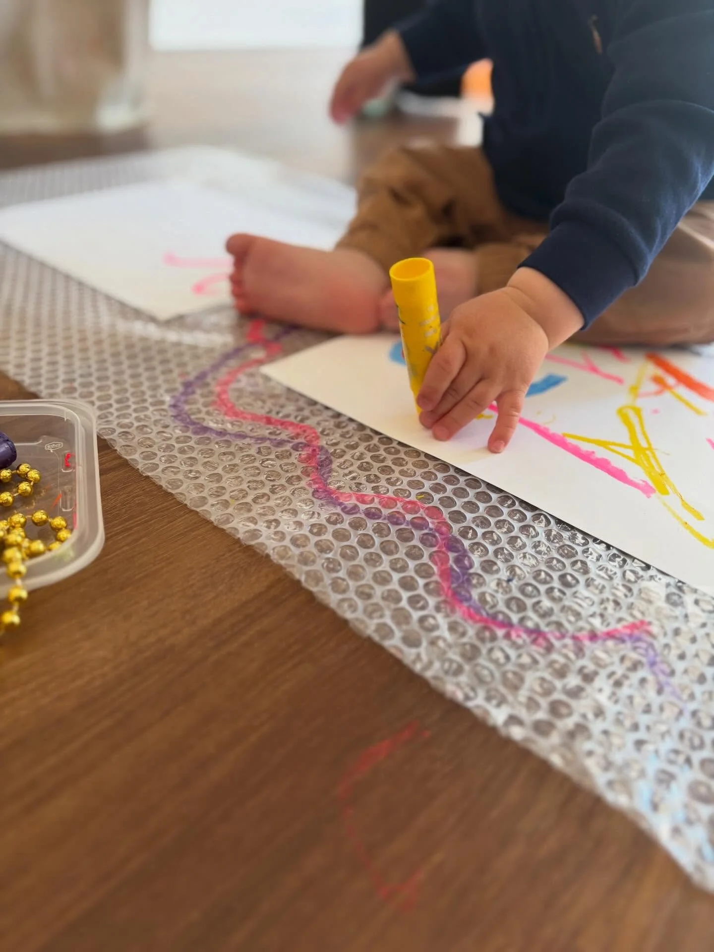 Our Messy Minis (6-18 months) group this morning explored ALL the provocations that were out today! We revisited mark-making with Kwik Stix, and brought back colorful ping-pong balls with tubes (so fun!) Some other familiar materials were out (like t