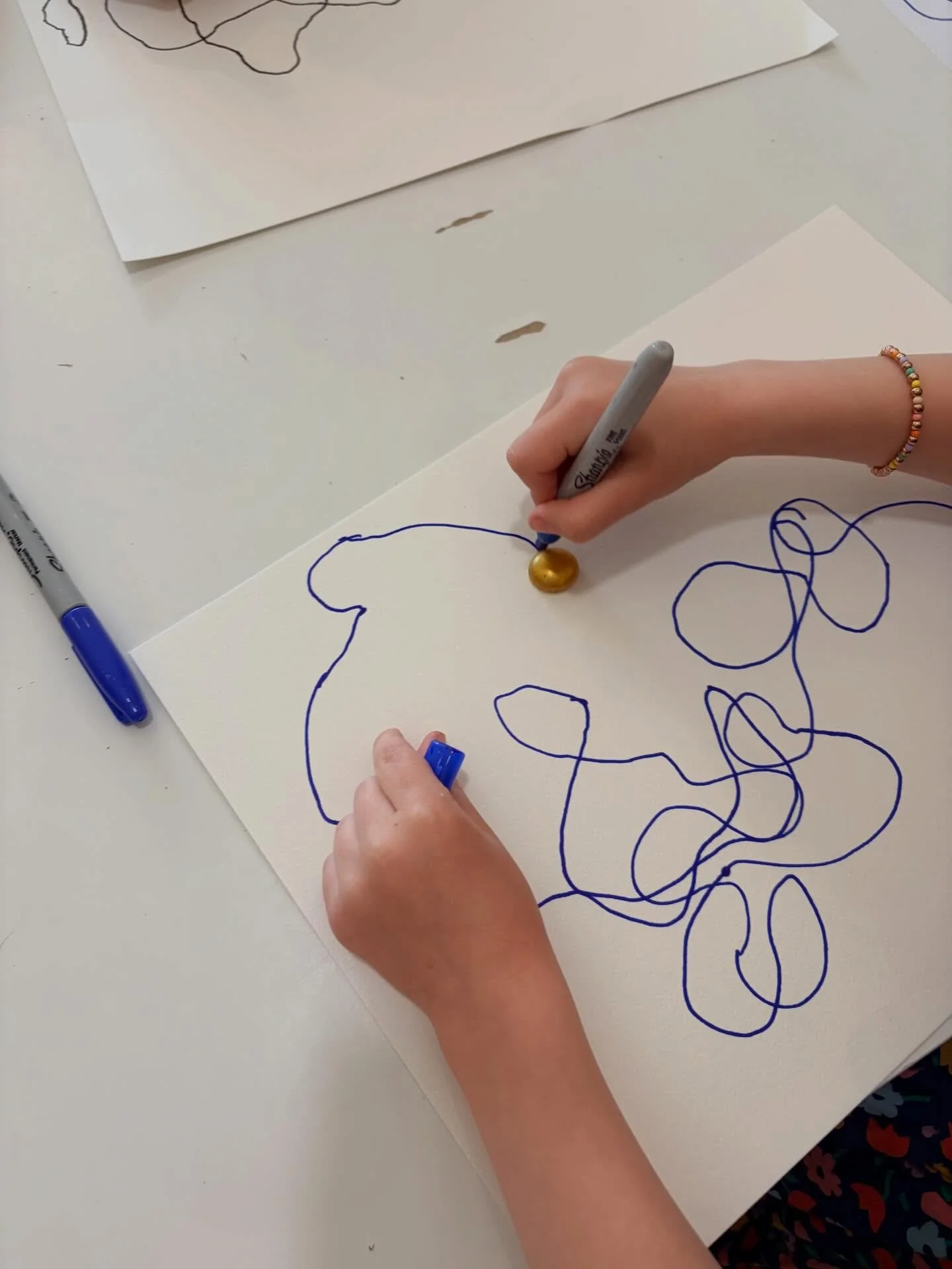 The Wednesday Afternoon Art Explorers (K-2nd grade) tried a new technique for creating lines and designs. They placed a gem on their paper and pushed it around with a marker. It was fun to see where the gem would go and what types of squiggles would 