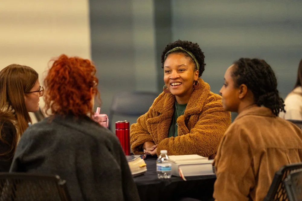 People gathered around tables talking at an Elevate City Church equipping night