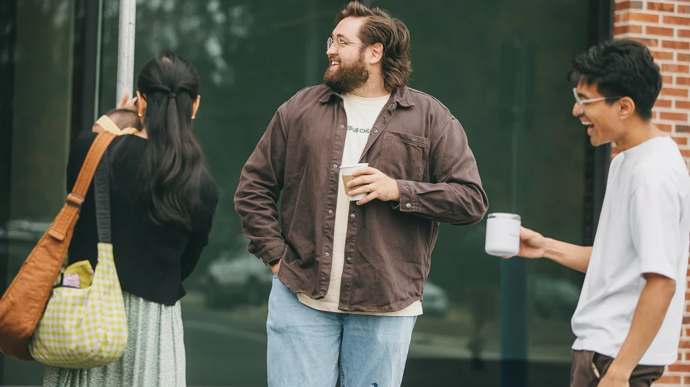 Two people sharing coffee and conversation outdoors