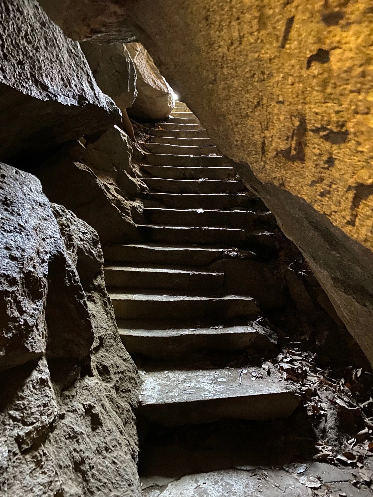 Stone staircase inside a cave leading toward sunlight, representing growth, transformation, and when coaching is a great fit.