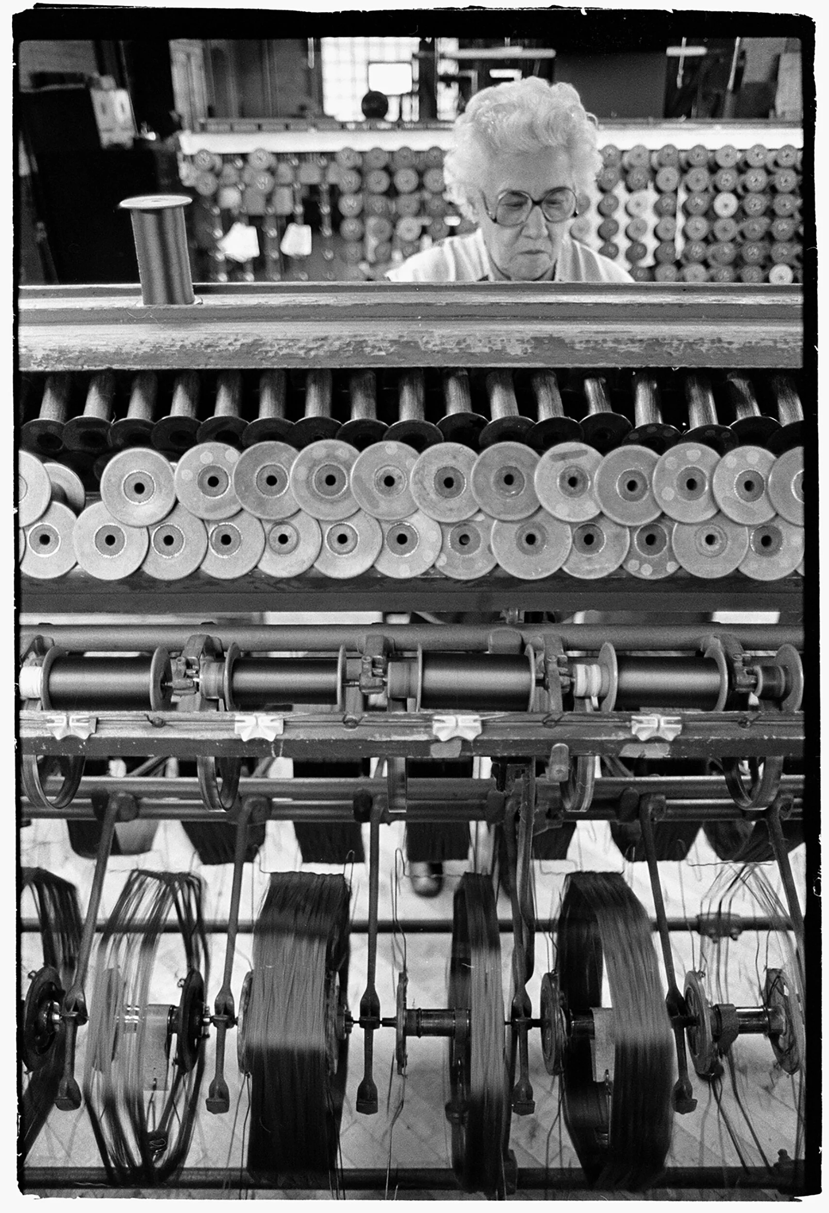 Anna Osika, a winder, watches as the silk thread is wound onto spools.