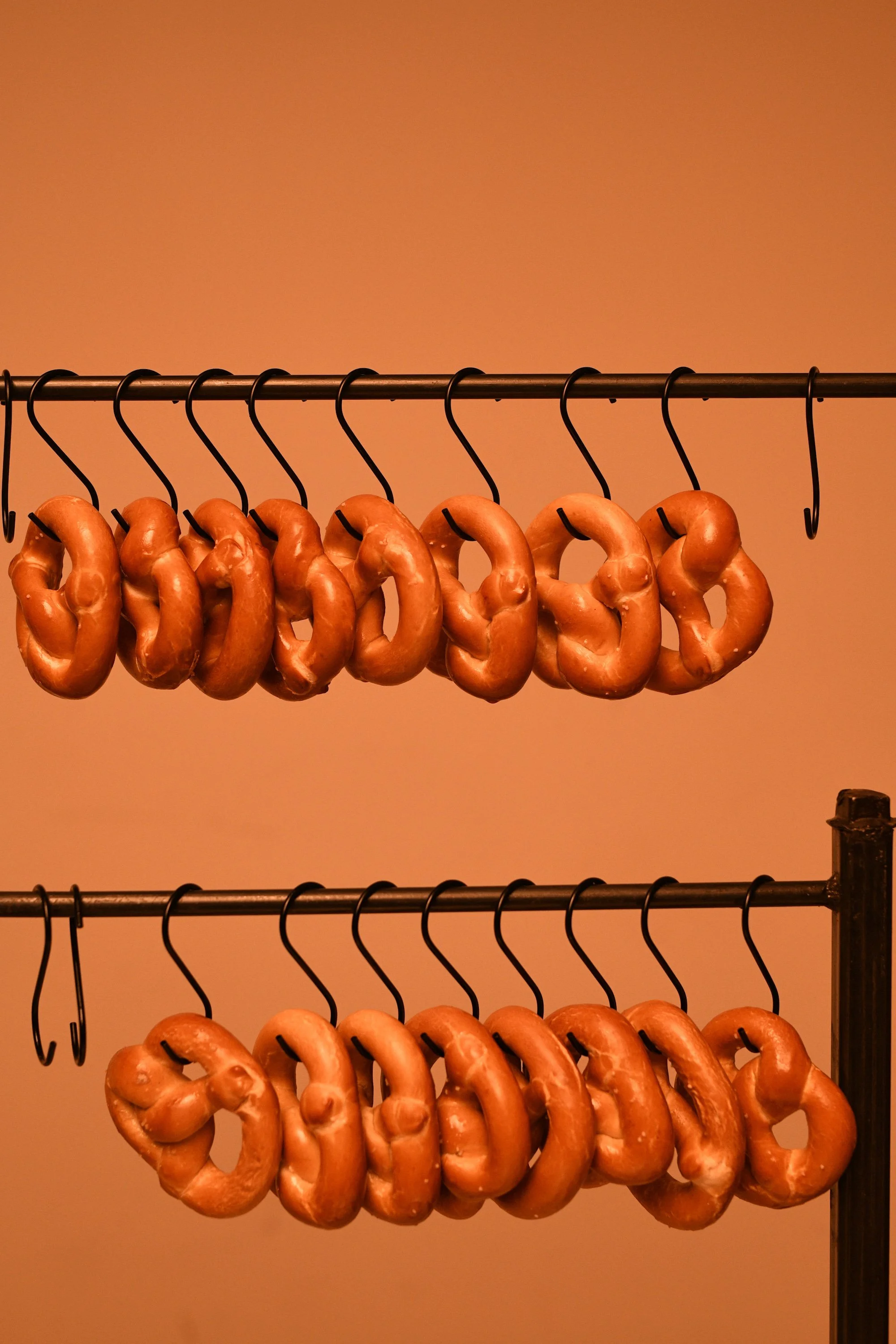 Soft pretzels hanging from a serving station display. Photo by Ed & Aileen.