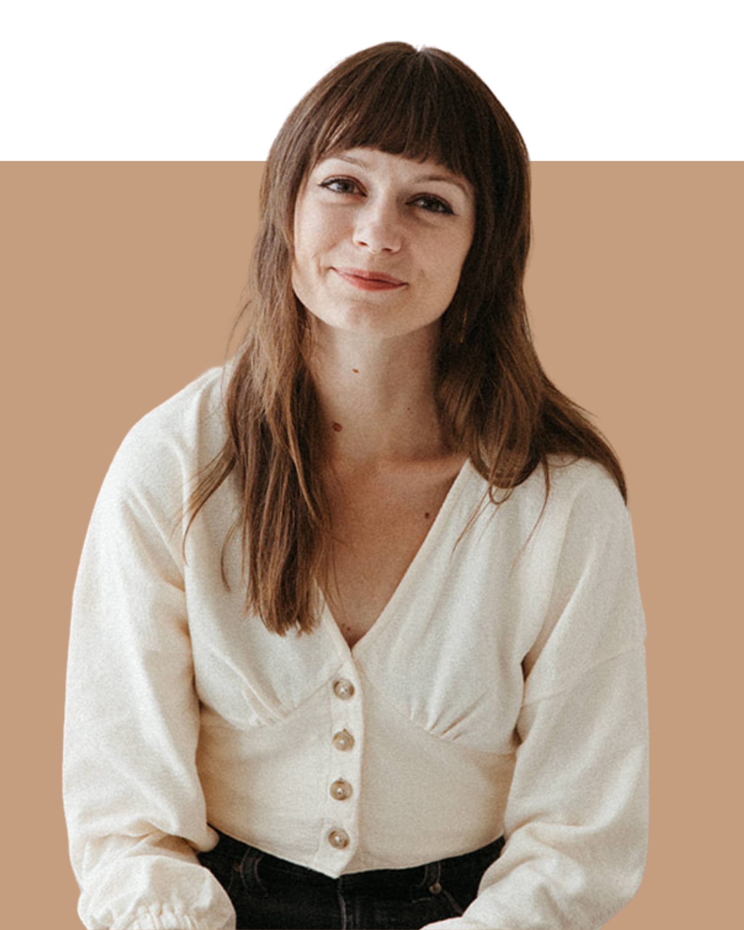 A woman with brown hair and bangs, wearing a light-colored button-up shirt, sitting against a beige background.