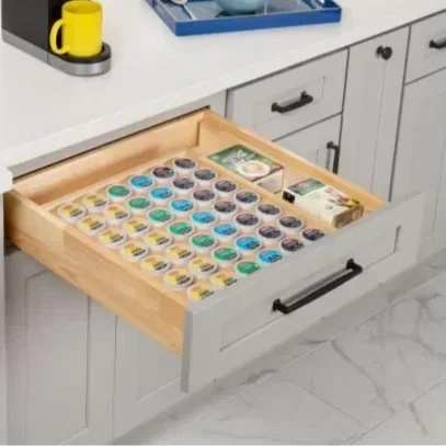 Drawer filled with various small containers of colorful paint or similar art supplies.