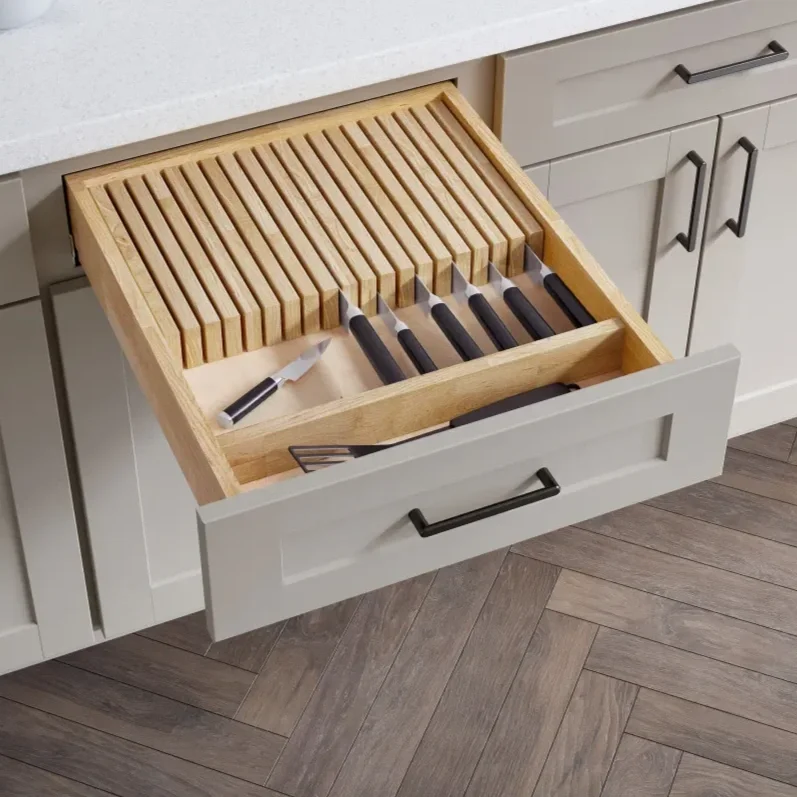 Kitchen drawer containing wooden cutting boards, knives, and a vegetable peeler.