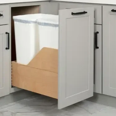 Open kitchen cabinet drawer with trash bags inside.