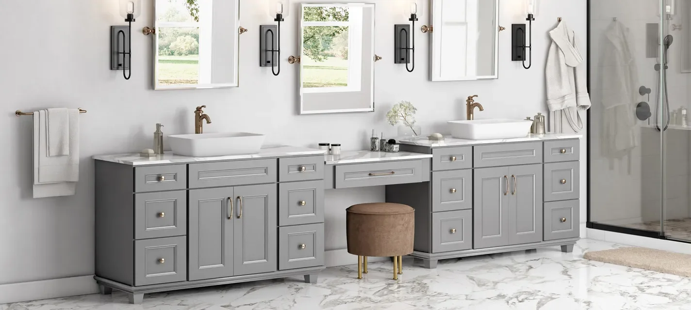 A modern bathroom with dual gray vanities, each with white vessel sinks and brass fixtures, mirrors, black wall-mounted light fixtures, a glass shower enclosure, and marble flooring.