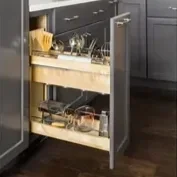 Open kitchen cabinet with cleaning supplies and miscellaneous items inside