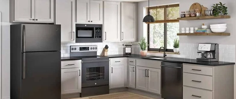 Modern kitchen with white cabinets, black appliances, a window, open wooden shelves, and various kitchen items.