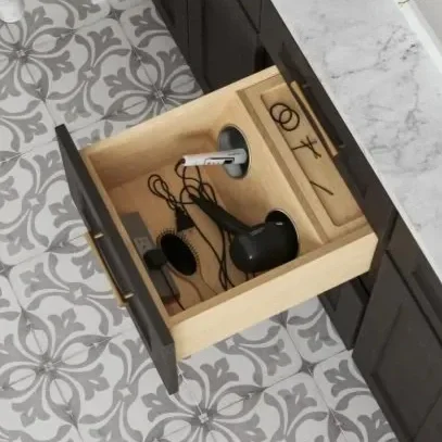 Open kitchen drawer with black and white earbuds, a pair of hair scissors, a hairbrush, and hair clips inside.