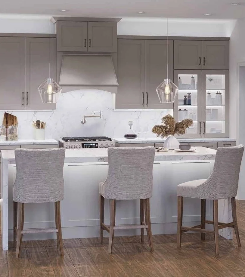 A modern kitchen with gray cabinets, white marble backsplash and countertop, three high-back bar stools, and pendant lights hanging above the island.
