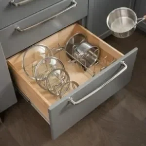 Kitchen drawer containing glassware and a metal pot.