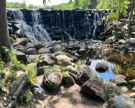 Waterfall at Whitnall Park. Small picnic area at the base of the waterfall. Short walk down a hill to access location.