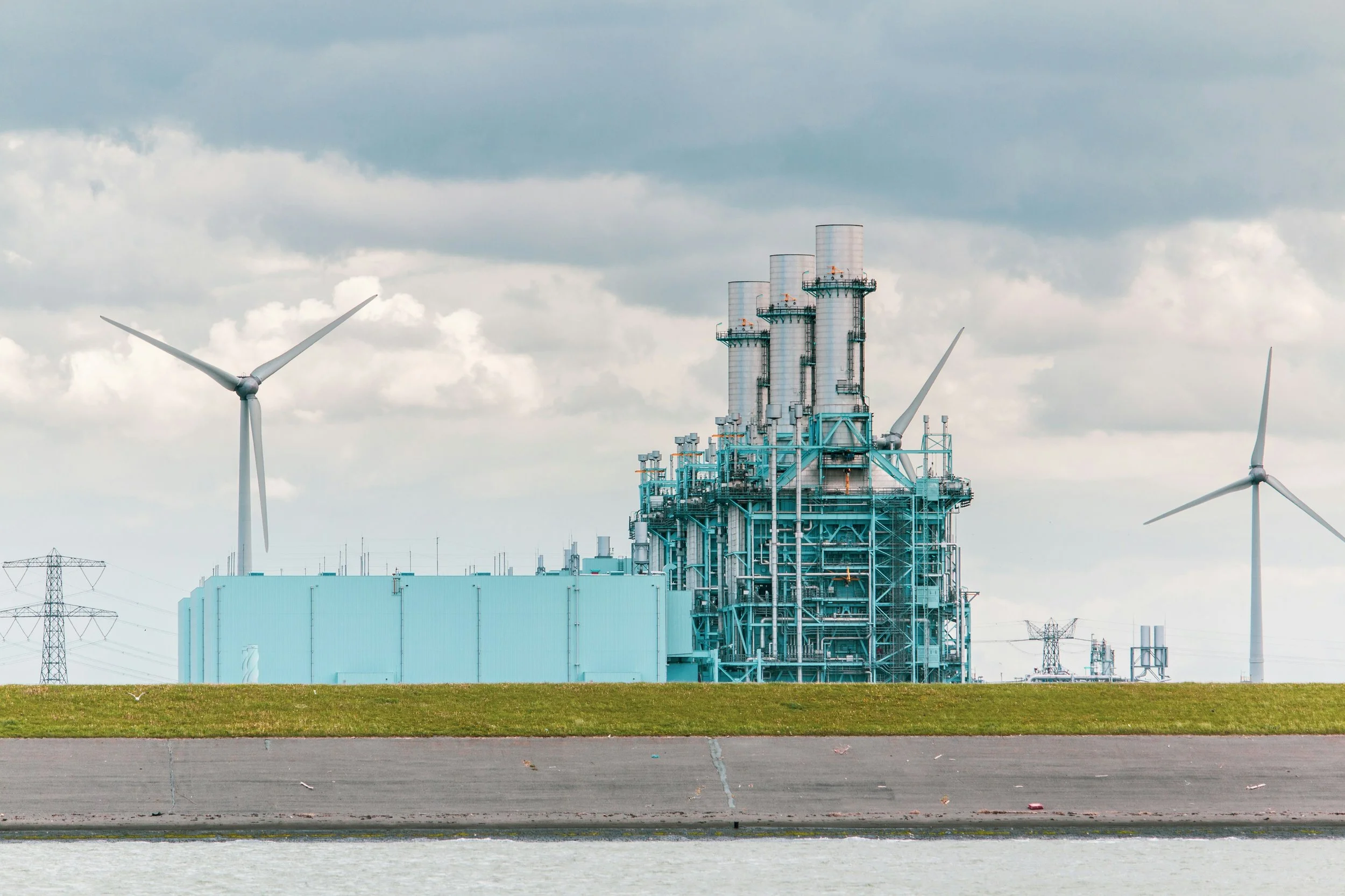 Energy production plant and wind farm surrounded by electricity grid