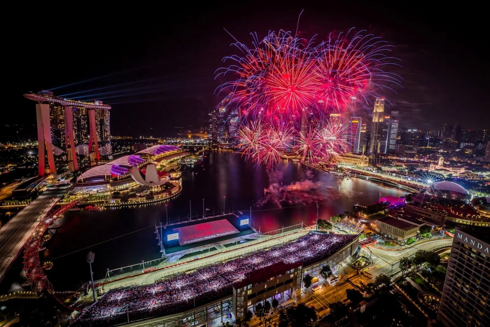 Panoramic night view of the Marina Bay Street Circuit illuminated under floodlights during the F1 Singapore Grand Prix.