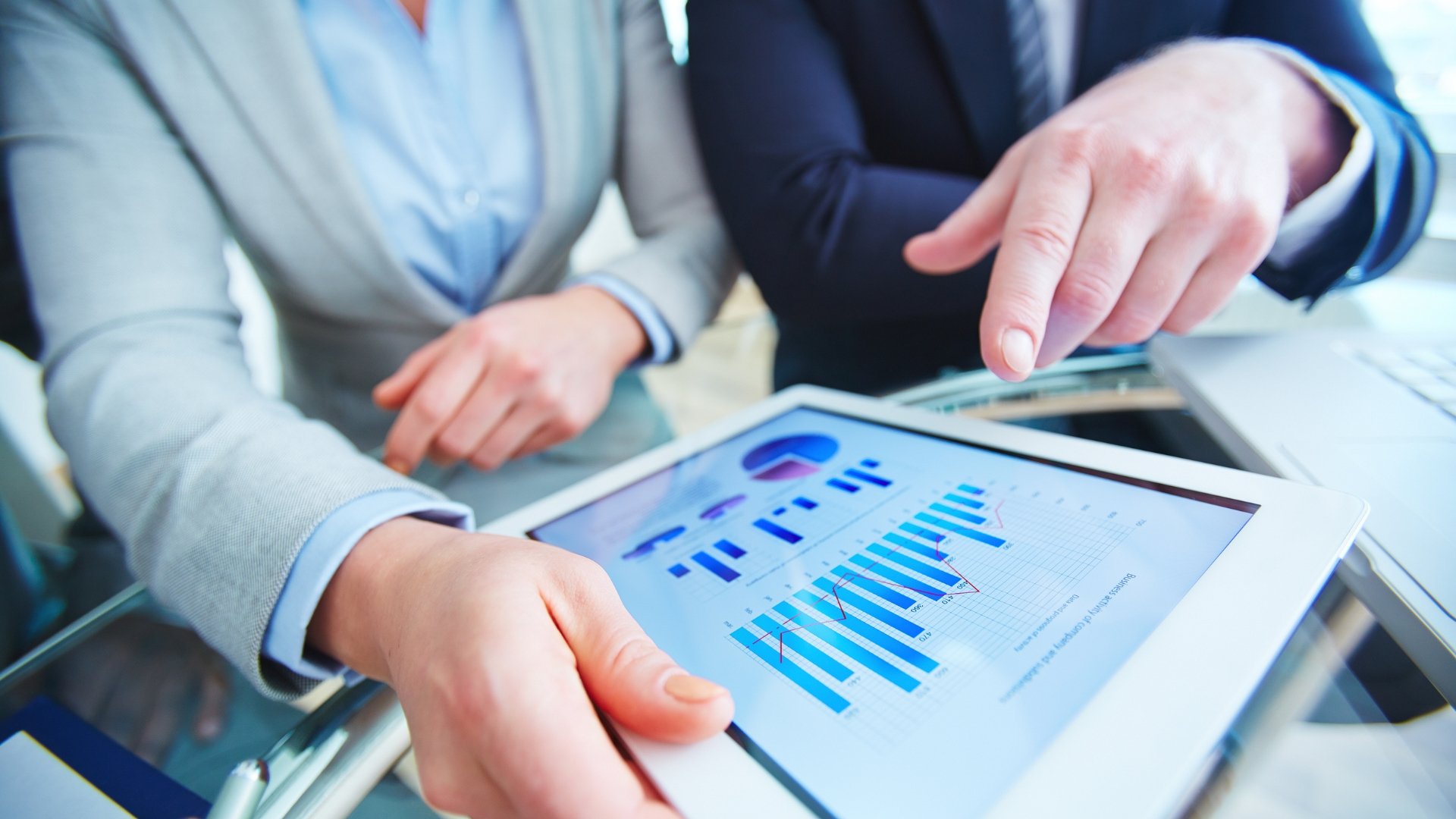A person reviewing financial documents and charts with a thoughtful expression, symbolizing regular financial review