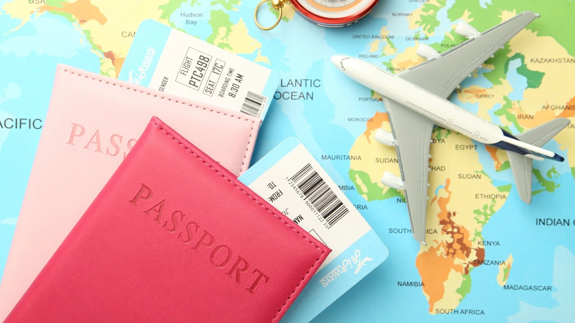 A leather passport holder and a smartphone displaying a global investment dashboard