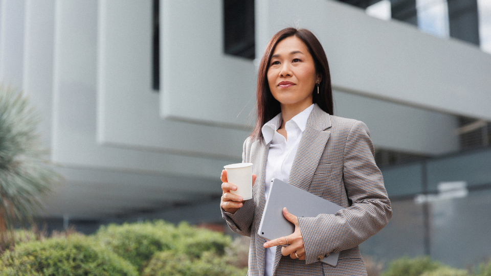 A young professional in Singapore managing personal budget and savings apps on a smartphone.