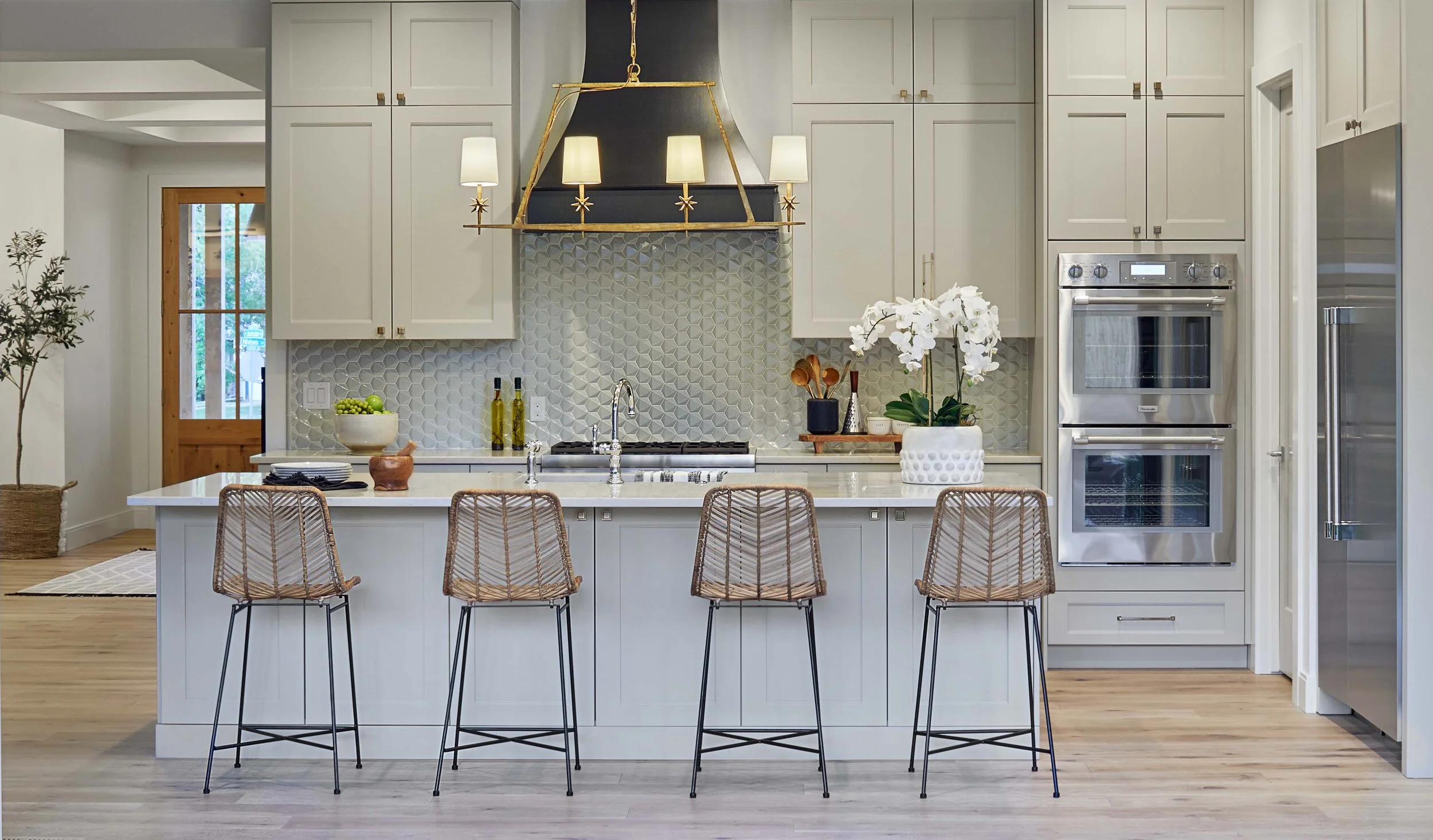 large open kitchen with creamy cabinets and a black range hood in a custom home built by smith & meade
