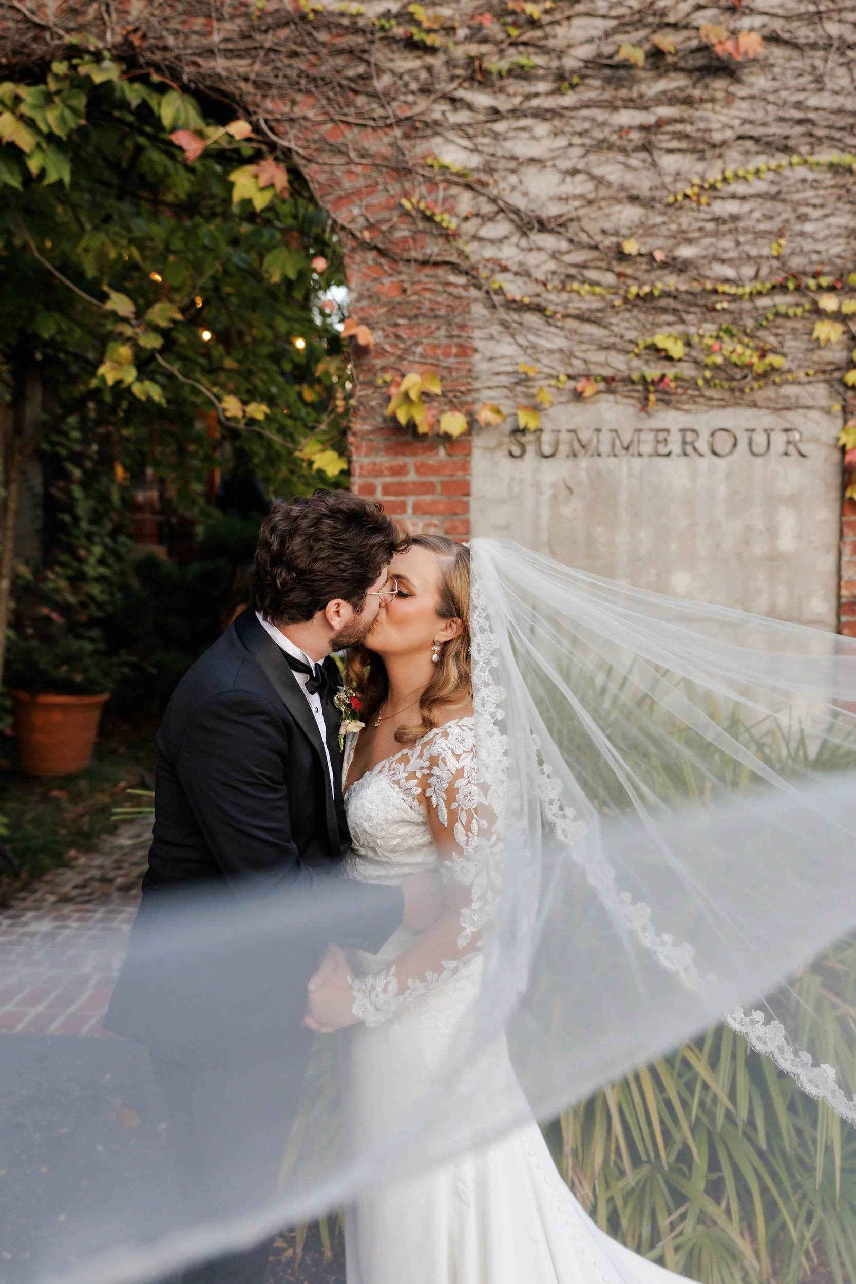 Bride and groom kissing with veil flowing to right at Summerour Studio wedding in Atlanta Georgia