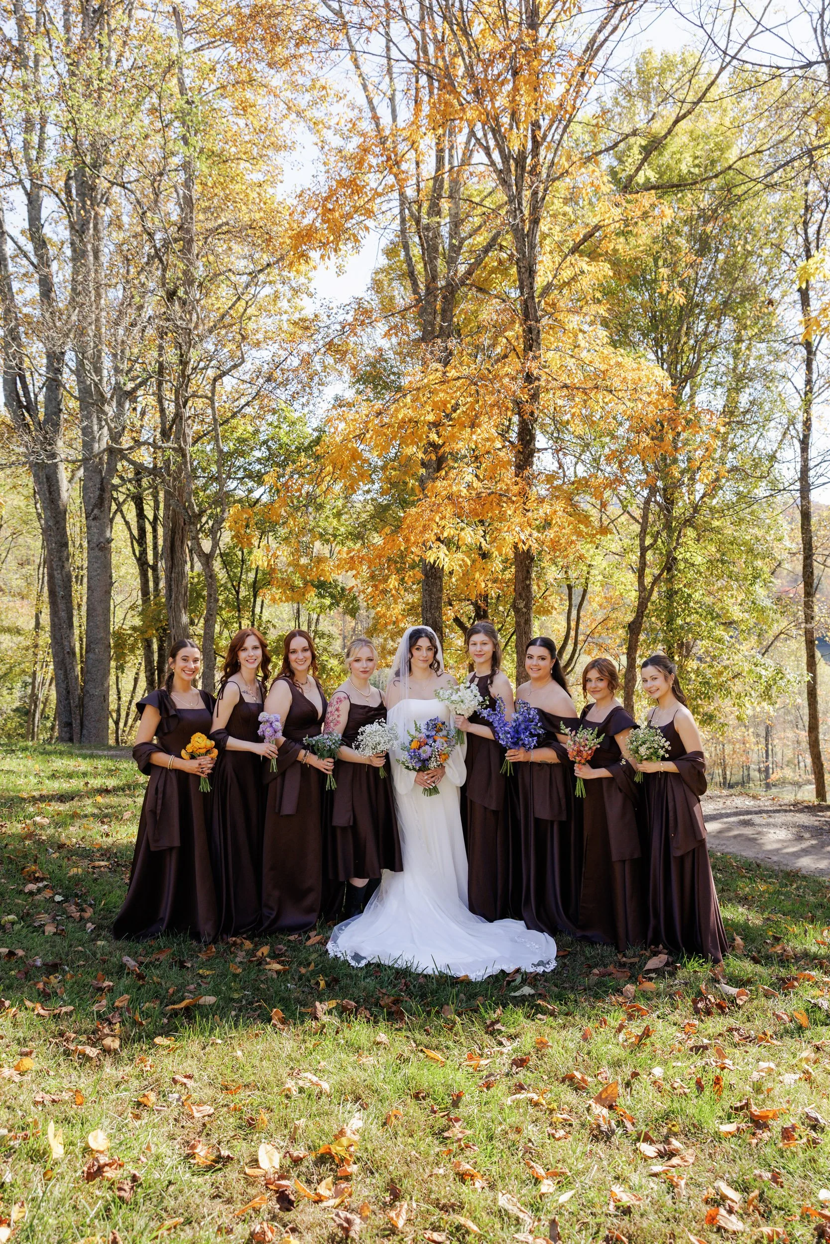 fall bridesmaids portrait with brown satin dresses and multicolor flowers at Vineyard at High Holly in Scaly Mountain, North Carolina
