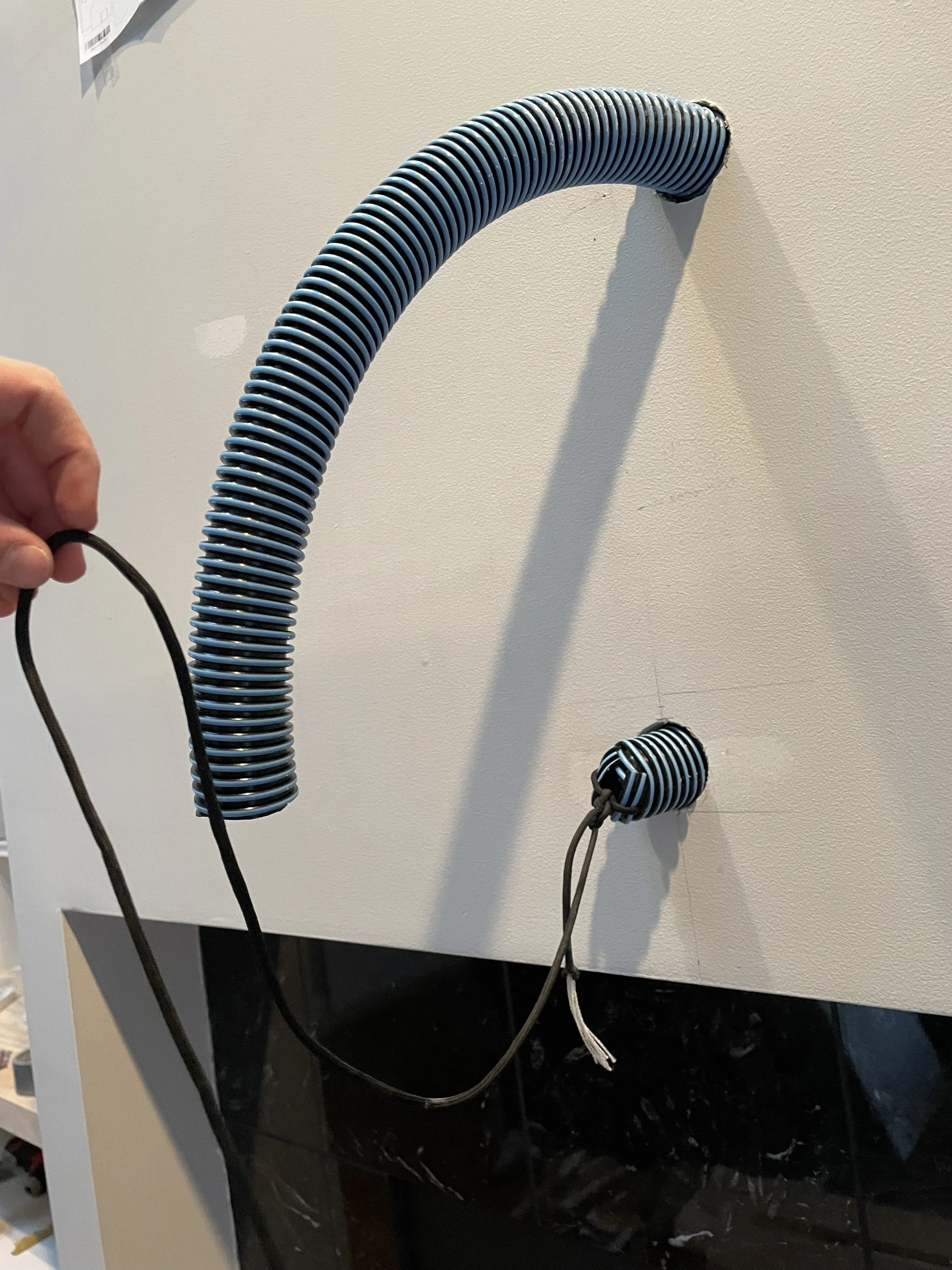 Creating a path for TV wires to be fed through the mantle and wall into the cabinet