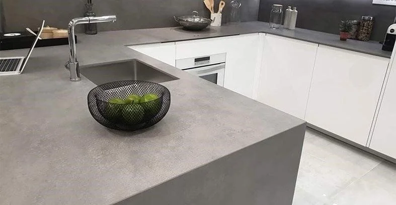 A sleek, modern kitchen with a matte concrete countertop and minimal, architectural styling