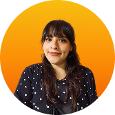 Mujer joven con cabello largo y oscuro, vestida con blusa azul con puntos blancos, sonriendo frente a un fondo naranja.