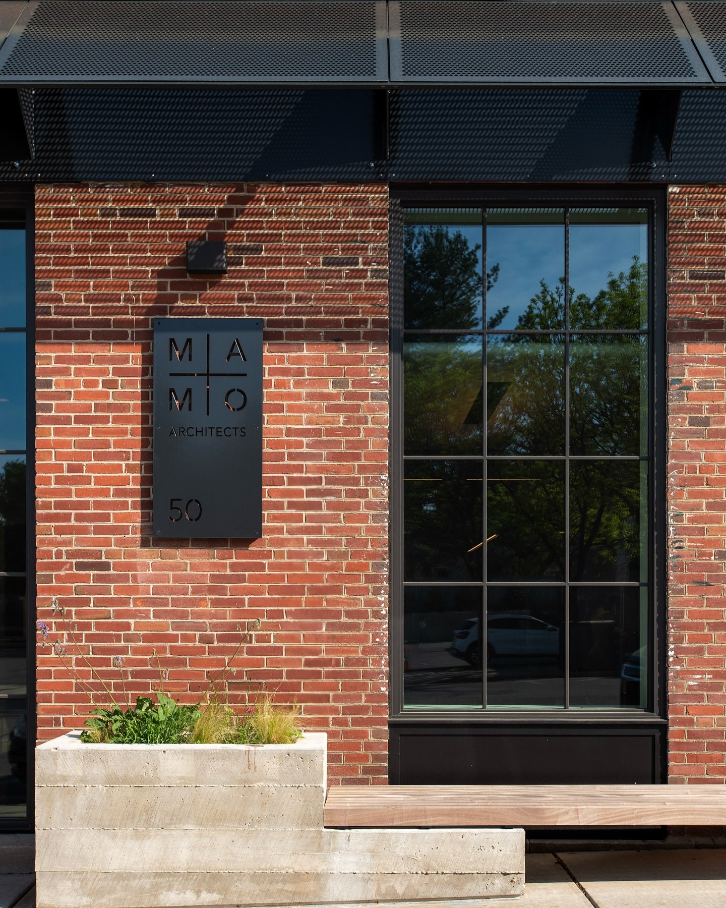 Board-formed concrete planters frame our studio&rsquo;s entrance, while integrated benches invite passersby to pause and connect with the building&mdash; blending architecture with the streetscape.
