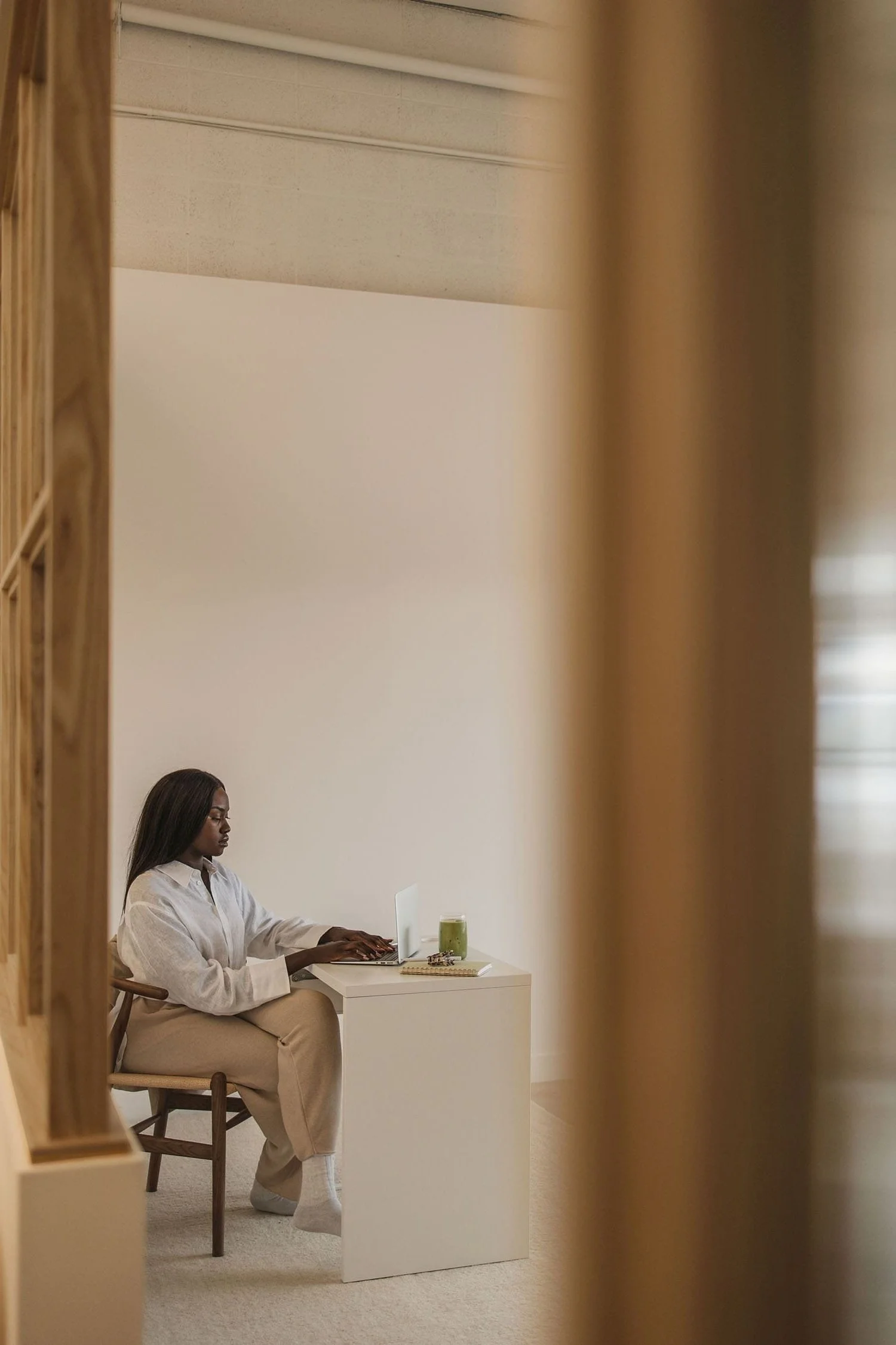 Black woman sitting at the front desk of a spa working on her computer