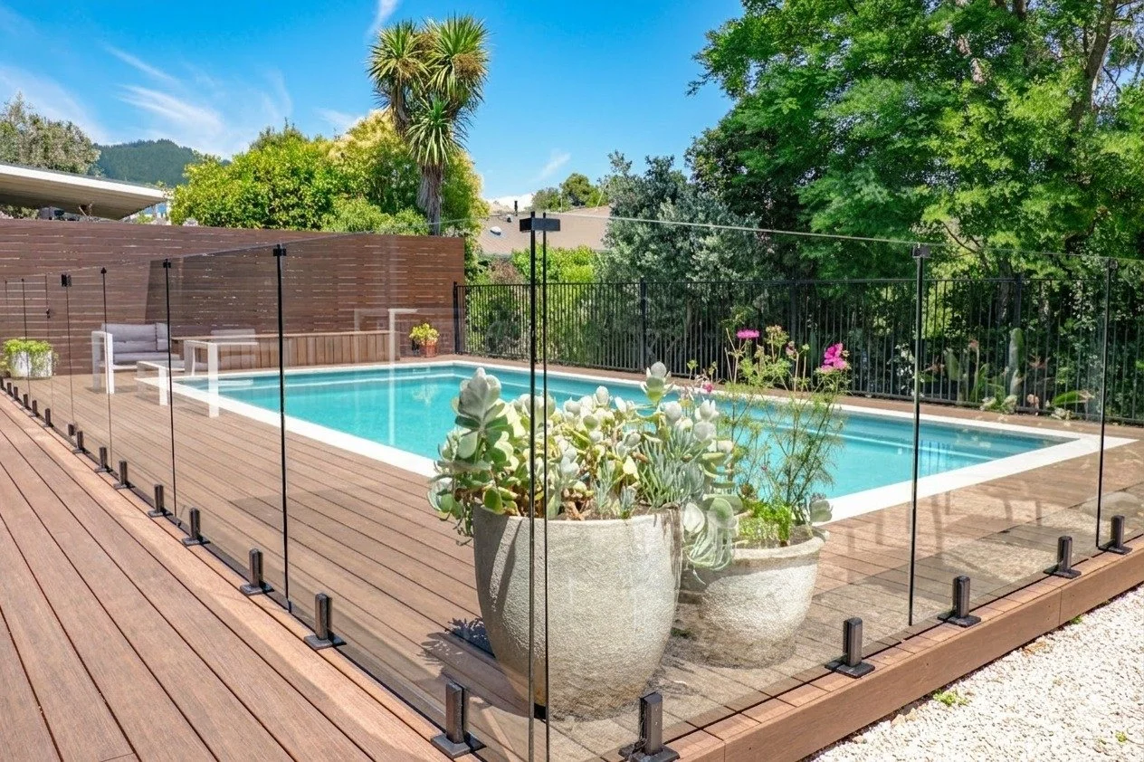 Pool safety that adds to the design. Frameless glass keeps the space feeling open and lets the timber detailing stand out.