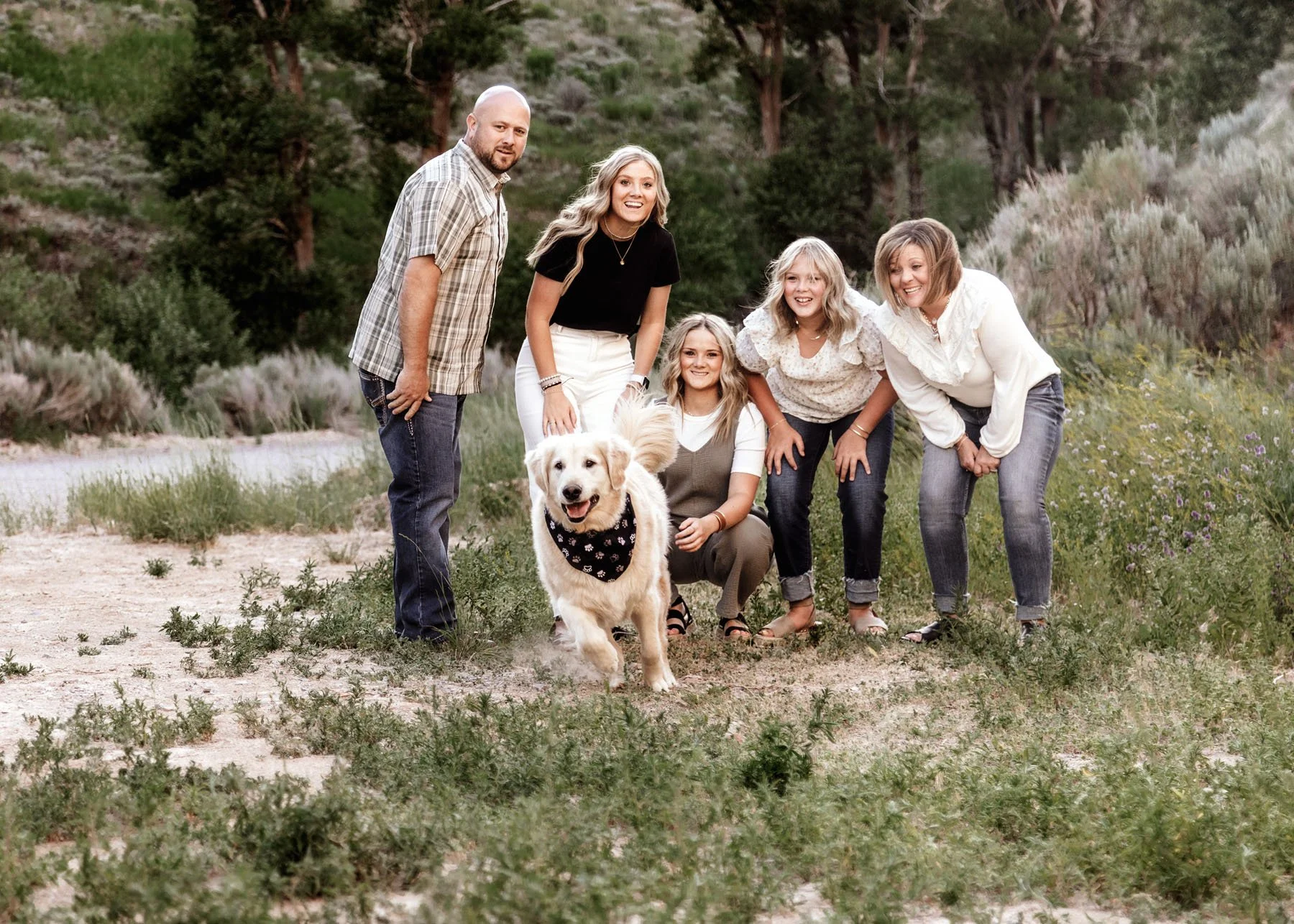 Happy dog chasing toy as family celebrates in rocky mountains