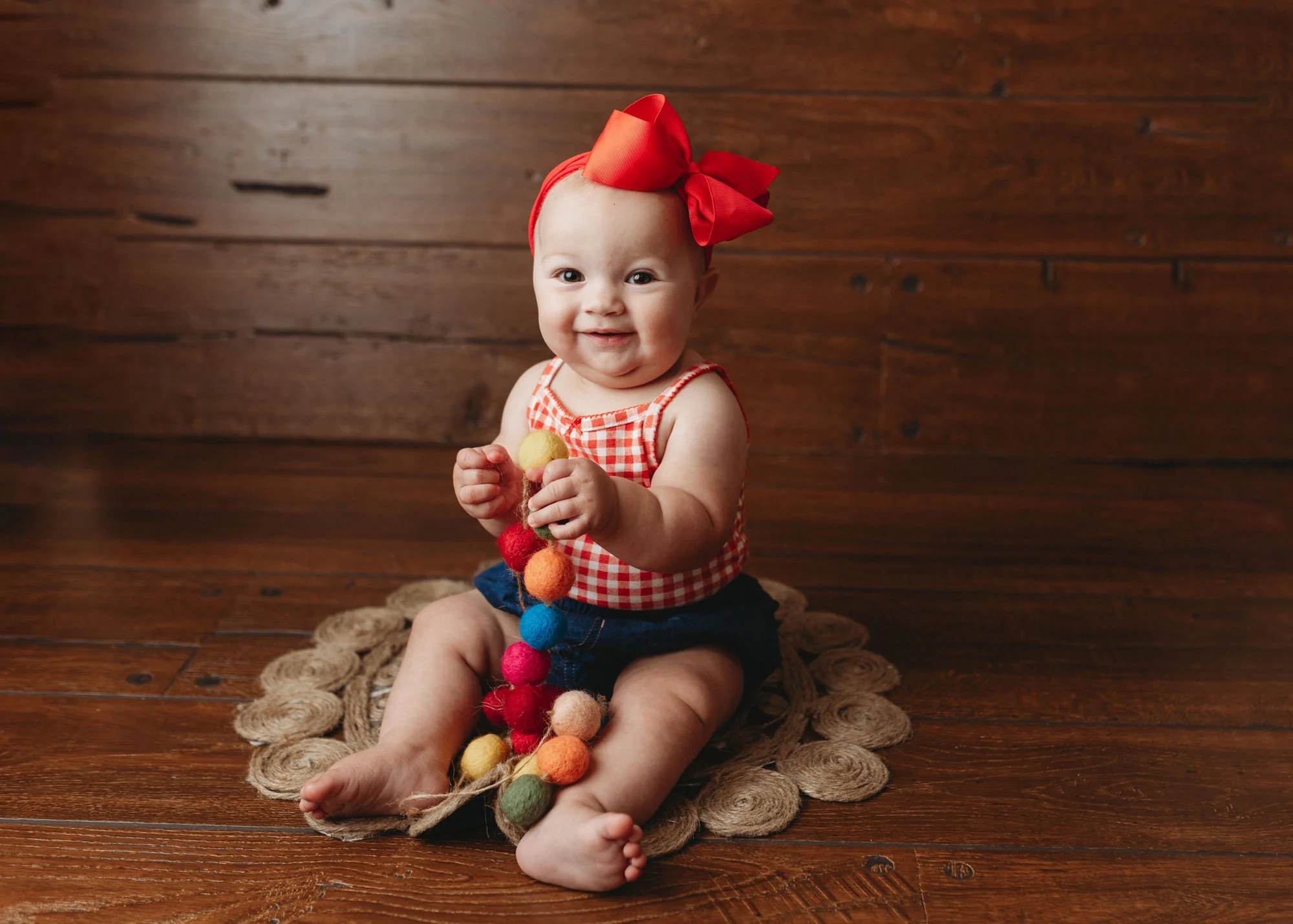 Infant playing with chain of balls during milestone session