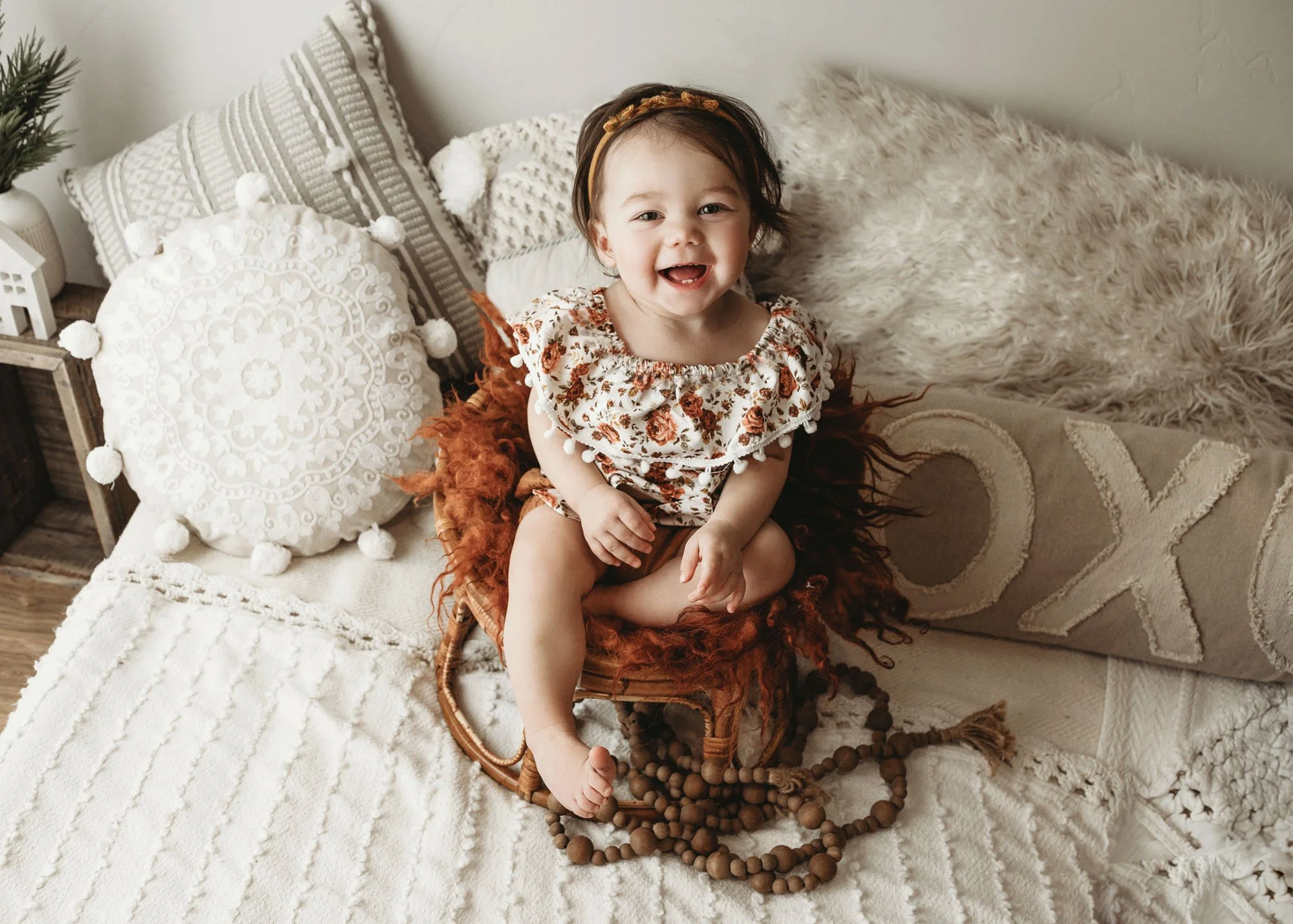 Baby sitting in basket with neutral studio backdrop