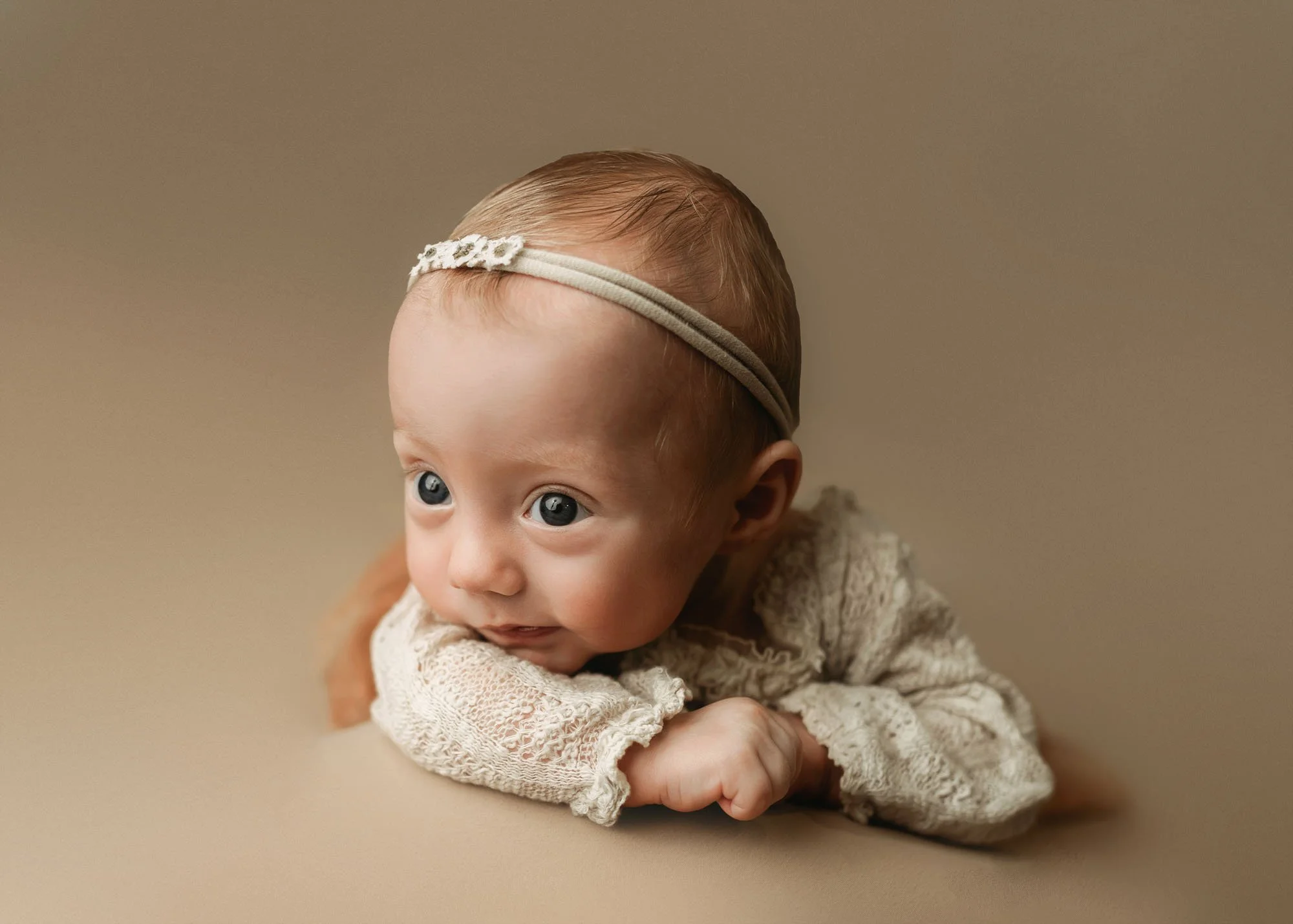 Infant milestone photography lifting head and smiling